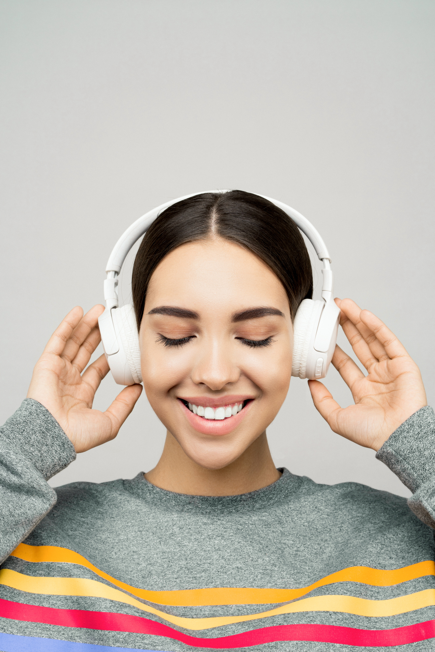 Woman in Gray Sweater Wearing White Headphones